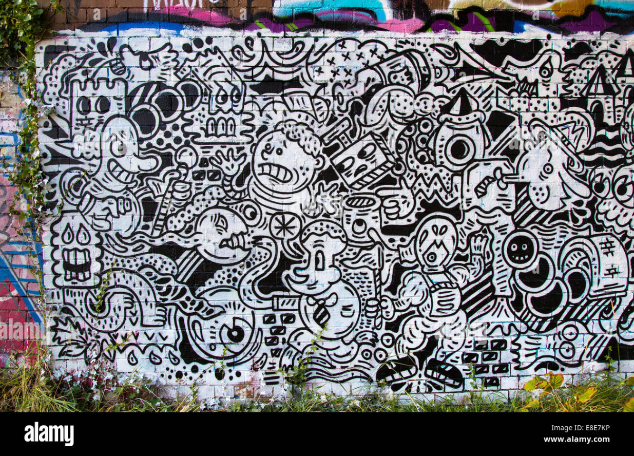 Cartoon graffiti in black and white under a railway bridge near