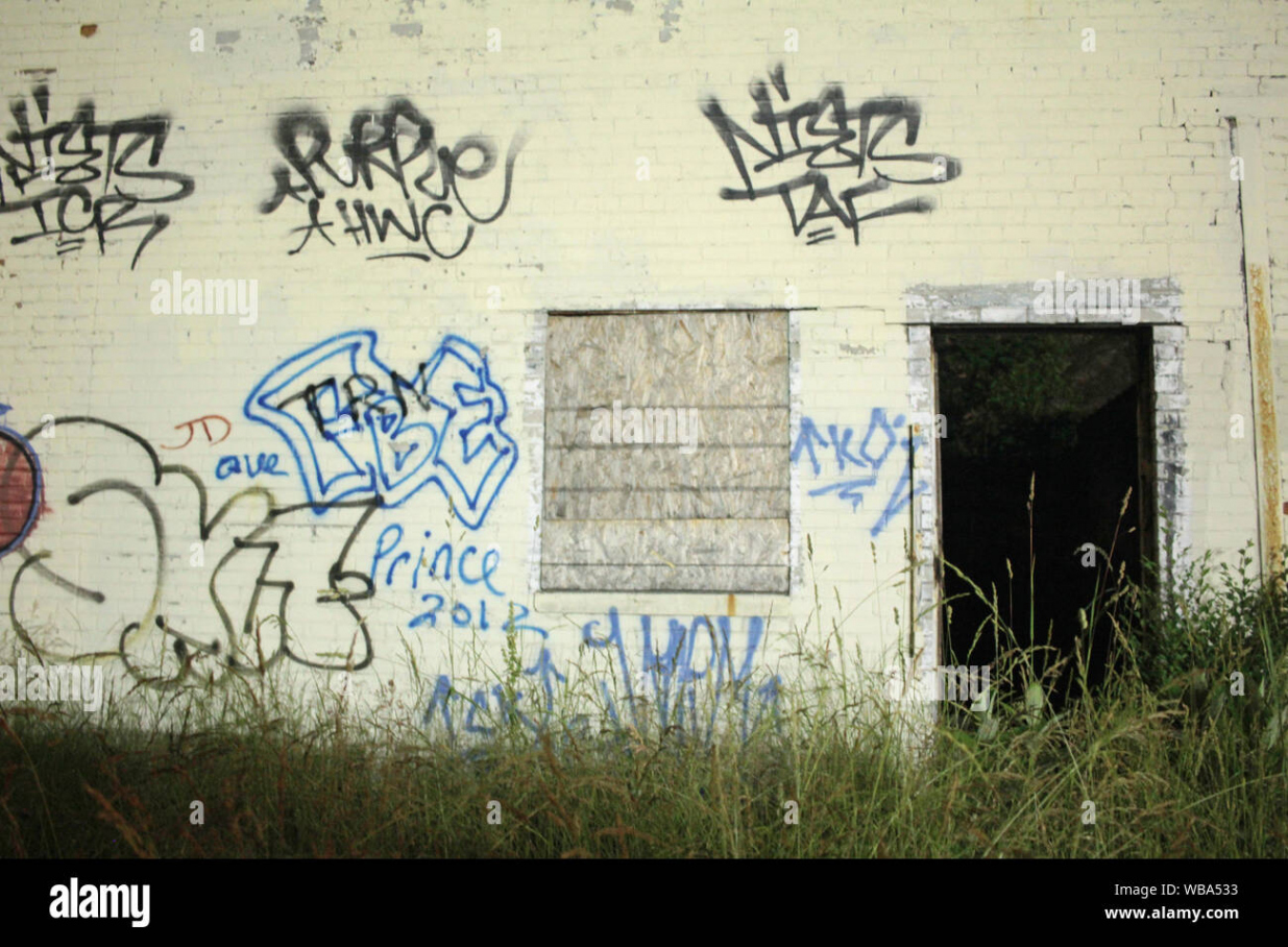 Gang grafitti sprayed on the wall of an abandoned building in